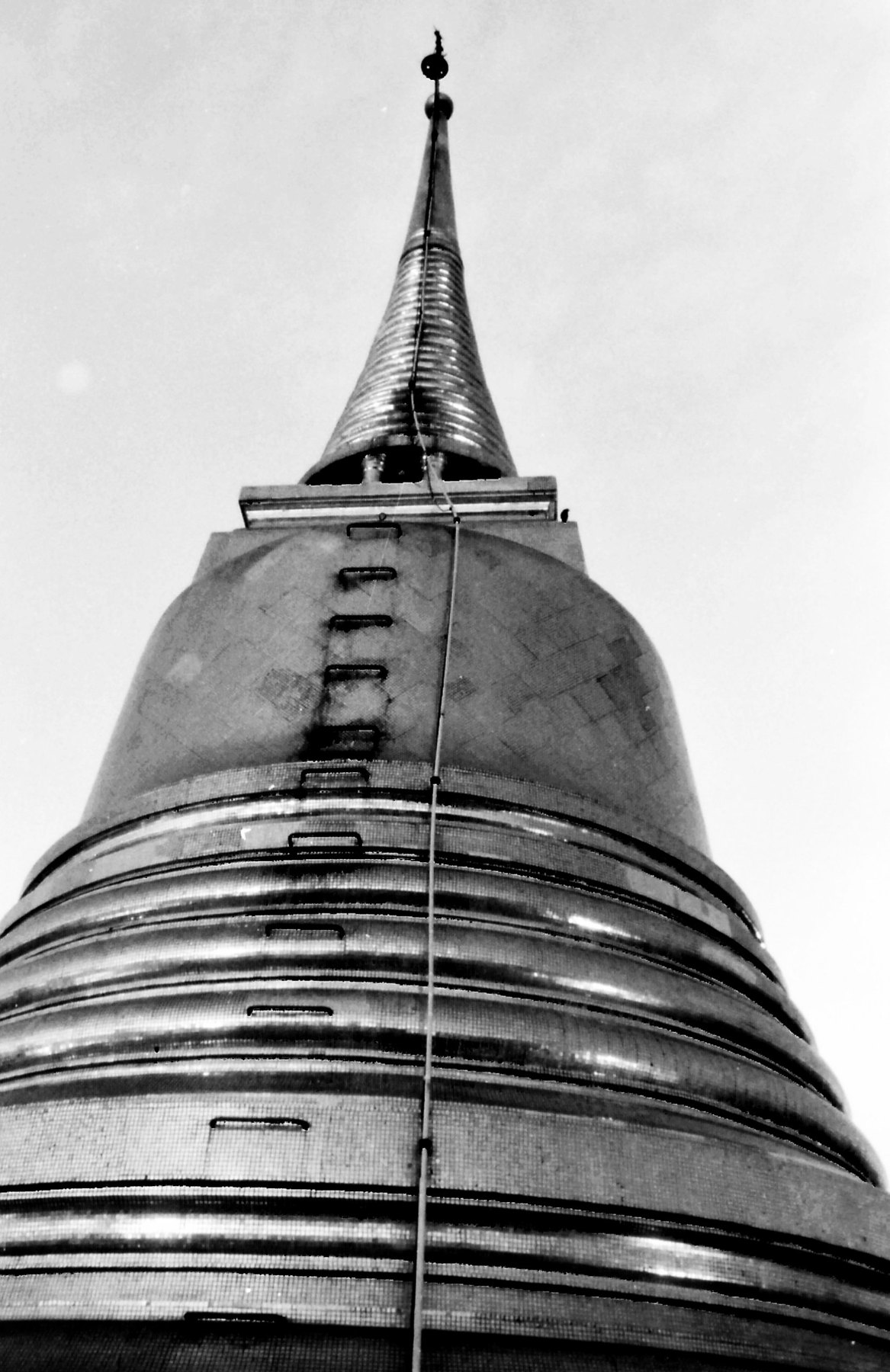 Schwarzweiß-Filmfoto mit Blick hinauf zur Spitze einer buddhistischen Tempel-Chedi in Bangkok, Thailand